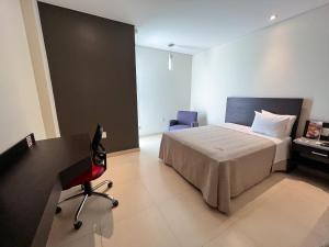 een slaapkamer met een bed, een bureau en een stoel bij Diverxo Hotel & Villas in Tuxtla Gutiérrez