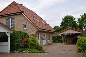 une maison en briques avec un portail et un garage dans l'établissement Aquarell, à Schönberger Strand