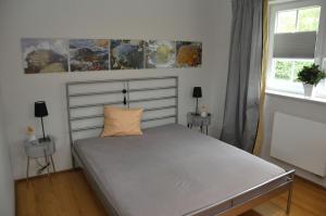 - un lit dans une chambre avec 2 tables et 2 fenêtres dans l'établissement Aquarell, à Schönberger Strand