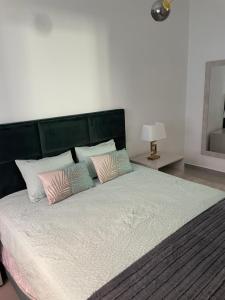 1 dormitorio con 1 cama grande con almohadas rosas y blancas en THE ORANGE TREE HOUSES - Frente by Live and Stay, en Abrantes
