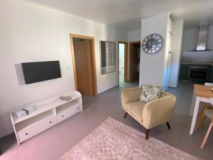 a living room with a tv and a chair at THE ORANGE TREE HOUSES - Frente by Live and Stay in Abrantes