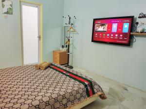 a bedroom with a bed and a flat screen tv at Kapar Homestay@Master Room/Private Bathroom/Private Car Park/1-2pax in Kapar