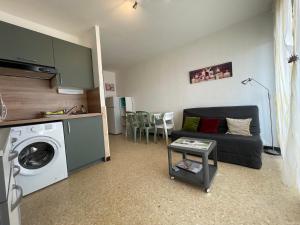 - un salon avec un canapé et un lave-linge dans l'établissement Studio Balaruc-les-Bains, 1 pièce, 2 personnes - FR-1-503-168, à Balaruc-les-Bains