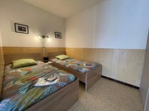 - 2 lits jumeaux dans une chambre avec une lampe dans l'établissement Studio Balaruc-les-Bains, 1 pièce, 2 personnes - FR-1-503-168, à Balaruc-les-Bains