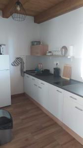 a kitchen with white cabinets and a black counter top at Chata u rybníka in Bohdalov