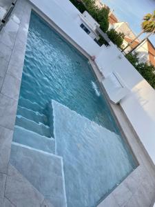 a swimming pool with stairs in the water at MEDITERRANEAN HOUSE - Habitaciones Privadas en Casa Compartida in Mairena del Aljarafe
