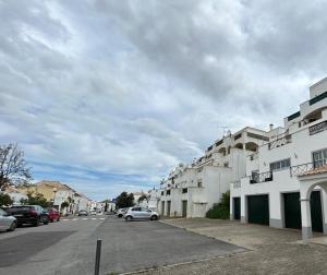 a street with cars parked in front of a building at Tavira near the center - two bedroom with balcony in Tavira