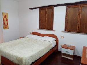 a small bedroom with a bed and two windows at La Casetta delle Farfalle in Lanciano