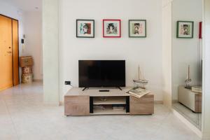 uma sala de estar com uma televisão de ecrã plano sobre uma mesa em AriadiMare em Molfetta