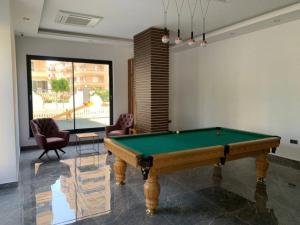 a living room with a pool table and chairs at One-bedroom apartment at Serenity Autumn promotion in Alanya