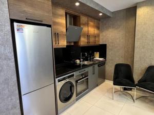 a kitchen with a refrigerator and a sink and a dishwasher at One-bedroom apartment at Serenity Autumn promotion in Alanya