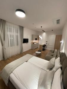 a bedroom with a large white bed and a couch at Central Apartments Sarajevo in Sarajevo