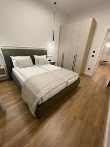 a bedroom with a large bed and a wooden floor at Central Apartments Sarajevo in Sarajevo