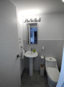 a bathroom with a sink and a toilet and a mirror at Luxury Apartment, 1110 Z.4 in Guatemala