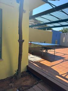 a picnic table on a deck with a tree at רגע מושלם in Shave Ẕiyyon