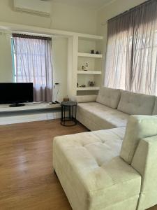 uma sala de estar com um sofá e uma televisão em רגע מושלם em Shavei Tzion