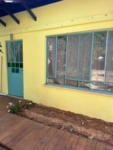 a yellow house with a blue door and windows at רגע מושלם in Shave Ẕiyyon