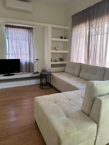 uma sala de estar com um sofá e uma televisão em רגע מושלם em Shavei Tzion