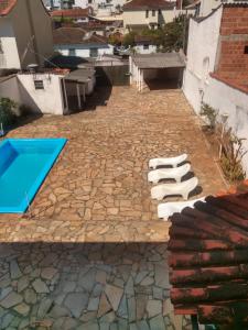 een patio met stoelen en een zwembad bij Pousada Samambaia SL in São Lourenço
