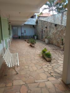 kamienny dziedziniec z ławką i budynkiem w obiekcie Pousada Samambaia SL w mieście São Lourenço