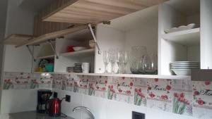 a kitchen with white cabinets with flowers on the wall at LA ESPERANZA in City Bell