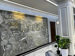 a large painting on a wall in a room at Royal Plaza in Qarshi