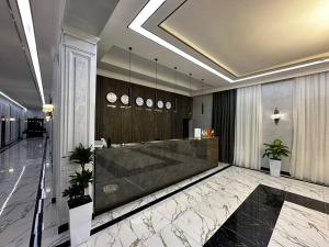 a lobby with a reception desk in a building at Royal Plaza in Qarshi