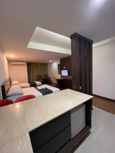 コタバルにあるSweet Studio Apartmentのベッド2台とプロジェクションスクリーンが備わるホテルルームです。
