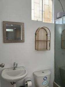 a bathroom with a sink and a toilet and a mirror at Casa Apartament Paseo Del Mar in Chimbote +21 photos