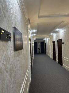 an empty hallway in a building with doors and a wall at Royal Plaza in Qarshi +22 photos