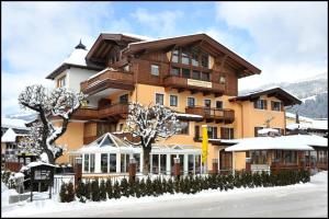 a large apartment building with snow on the ground at Appartements Lorenzoni, Cafe Konditorei Helmut Lorenzoni in Kirchberg in Tirol