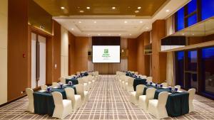 a conference room with rows of chairs and a screen at Holiday Inn Haikou West Coast, an IHG Hotel in Haikou