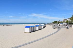 een strand met een rij strandhutten erop bij Dar Lila Cote d'Opale in Saint-Martin-Boulogne