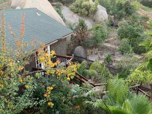 a garden with flowers and a house with a roof at The Cottage at Mount Woodson in Ramona