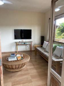 ein Wohnzimmer mit einem Couchtisch und einem TV in der Unterkunft Casa Nice Trancoso in Trancoso