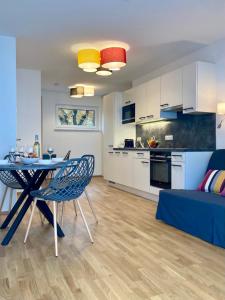 uma cozinha e uma sala de estar com mesa e cadeiras em Promenade by BestChoice - Self Check-in with Parking Option em Graz