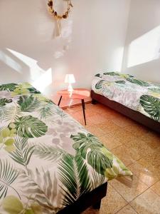 ein Schlafzimmer mit 2 Betten und einem Tisch mit einer Lampe in der Unterkunft 3 private rooms shared flat in a villa at Sceaux 600m RER B direct to Notre-Dame in Sceaux