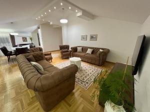 - un salon avec deux canapés et une table dans l'établissement Silver Gate Apartment Sarajevo, à Sarajevo