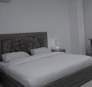 a bedroom with a large bed with white sheets and pillows at Petra Gardens in Wadi Musa