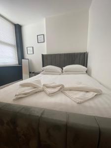 Luxevibe apartment في بلاكبول: سرير أبيض كبير مع ملاءات ووسائد بيضاء