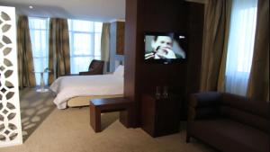 a bedroom with a bed and a tv in a room at HOTEL BENI HAMAD in Bordj Bou Arreridj