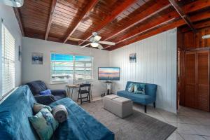 a living room with a blue couch and a tv at Waterfront Cozy Cottage with Boat Ramp & Dock in Little Torch Key