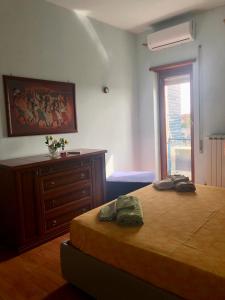 sypialnia z łóżkiem, komodą i oknem w obiekcie MomòHouse - 4 ospiti 2 camere WiFi A/C w Rzymie
