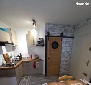 a kitchen with a sink and a brick wall at Petit appartement T2 30m2 in Aix-les-Bains