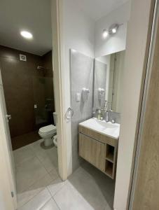 a bathroom with a sink and a toilet and a mirror at Paseo Quattro Villa Carlos Paz in Villa Carlos Paz