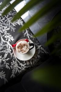 a cup of coffee on a plate on a table at Hotel Santiny in Sveta Nedelja