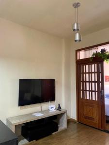 uma sala de estar com uma televisão de ecrã plano na parede em Apartamento em Copacabana no Rio de Janeiro