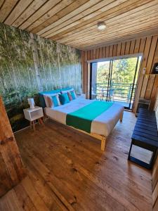 a bedroom with a large bed and a large window at Lodge Los Bosques in Matanzas
