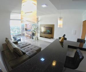 - un salon avec un canapé, une table et une télévision dans l'établissement TH Flats GV Shopping 403, à Governador Valadares