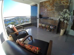 uma sala de estar com um sofá e cadeiras e uma janela em TH Flats GV Shopping 403 em Governador Valadares